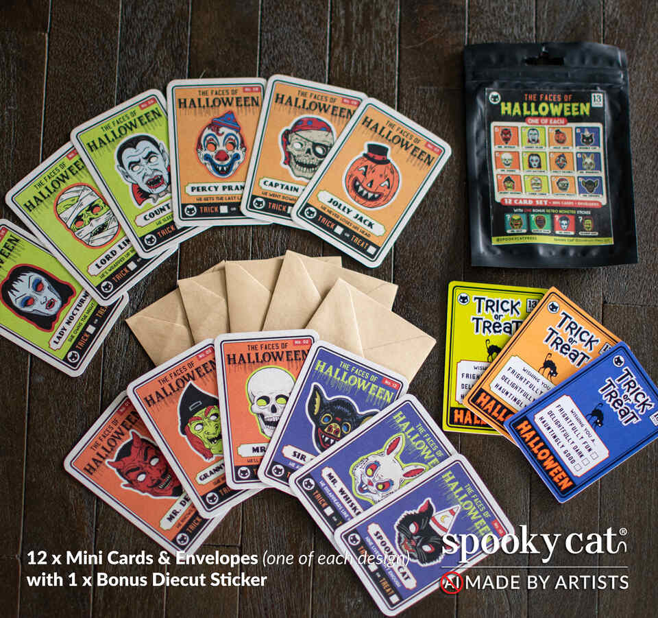 A flat-lay of Spooky Cat's 'Faces of the Halloween' mini cards and envelopes on a dark wood background, with a bonus die-cut sticker and mini-matching brown envelopes. The cards feature colorful vintage illustrations of various Halloween masks as character trading cards.