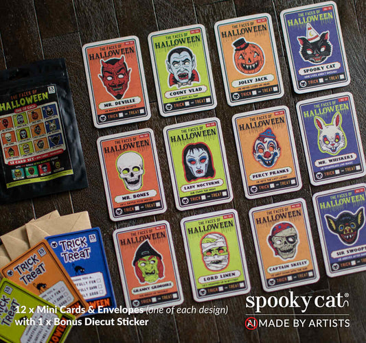 A flat-lay of Spooky Cat's 'Faces of the Halloween' mini cards and envelopes on a dark wood background, with a bonus die-cut sticker and mini-matching brown envelopes. The cards feature colorful vintage illustrations of various Halloween masks as character trading cards.