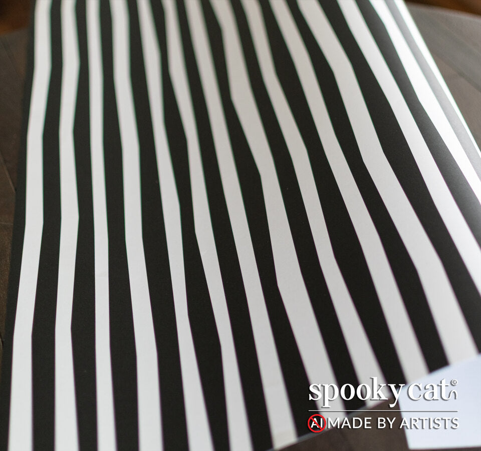 Flat view of gothic Halloween gift wrap showing black and white irregular stripes.