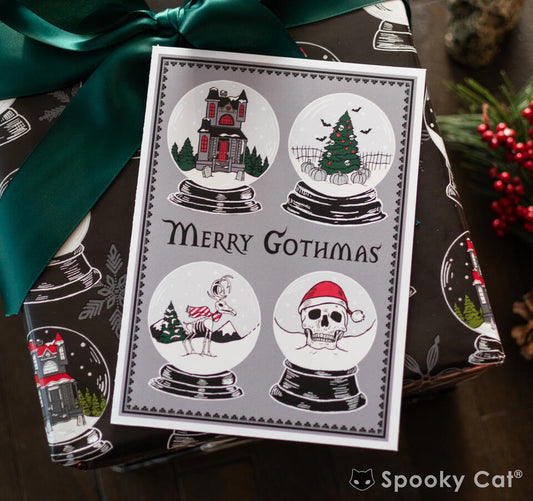 Merry Gothmas card with four spooky snow globes featuring haunted house, Christmas tree, skeleton bird, and skull in Santa hat. Perfect for Creepmas