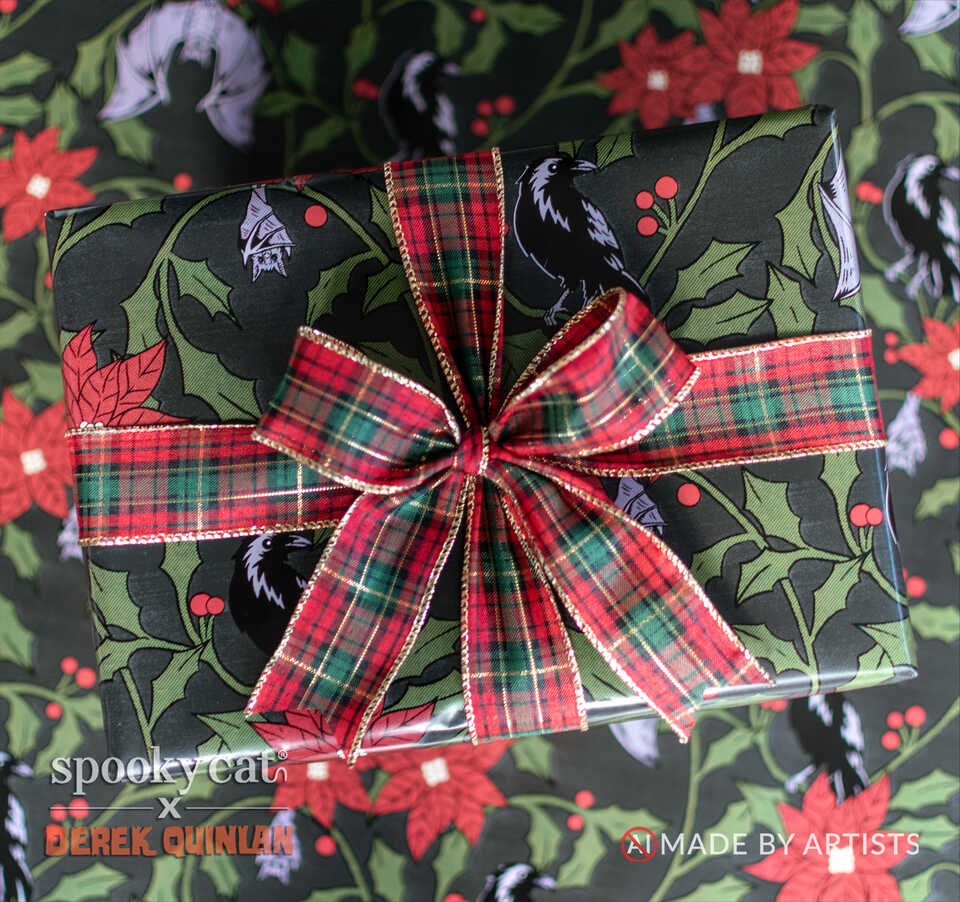 Christmas present wrapped in Gothic Victorian Yule Floral gift wrap with ravens, bats, poinsettias and holly, finished with a festive plaid bow.