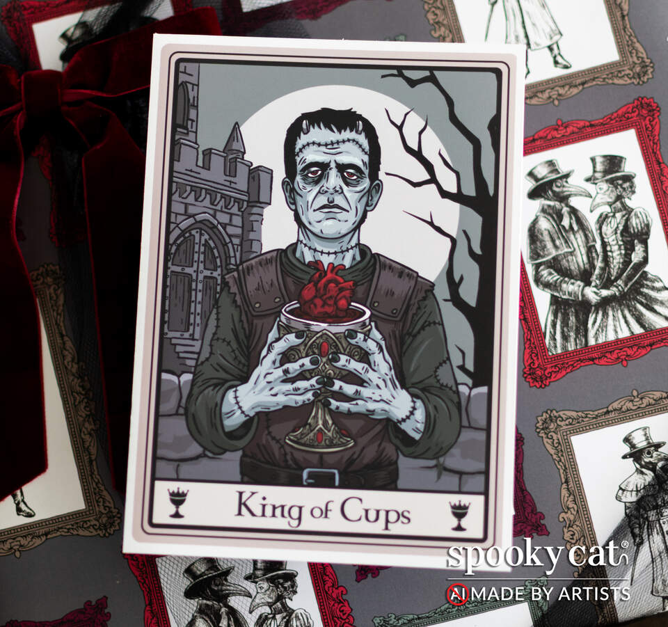 King of Cups tarot card with gothic Frankenstein-inspired figure styled with patterned wrap and ribbon, showing heart chalice and castle background