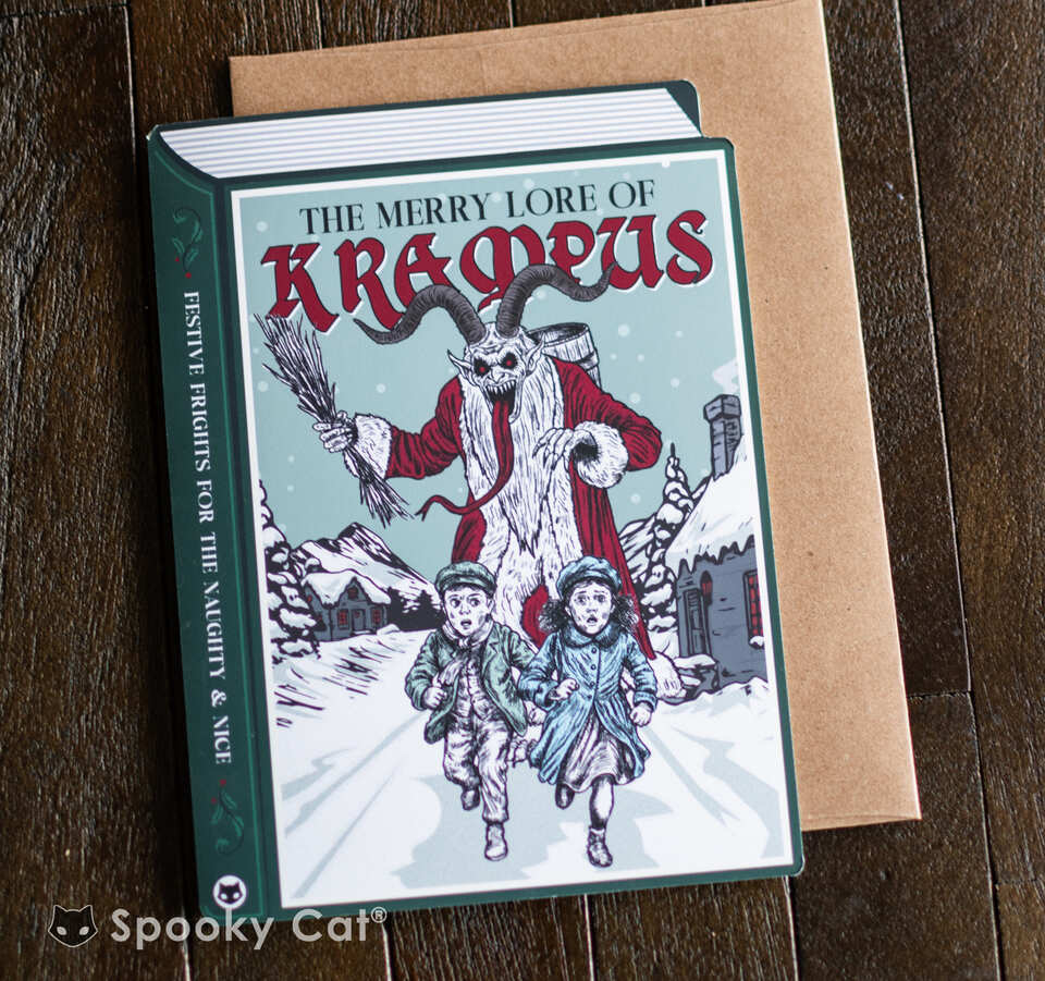 Book-shaped Krampus Christmas card featuring the Merry Lore of Krampus chasing children through a snowy village