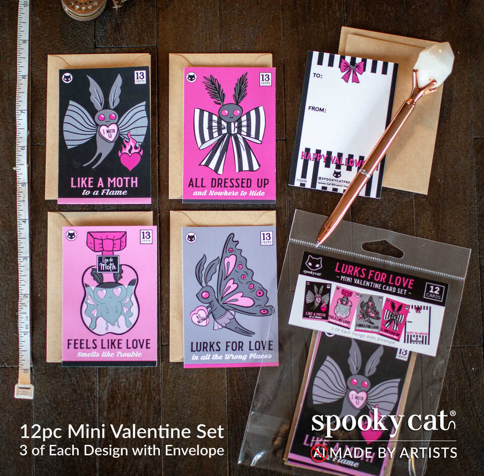 Mothman Valentine’s Set featuring 12 mini Valentine cards with spooky moth designs, pink and black artwork, and matching envelopes laid out flat