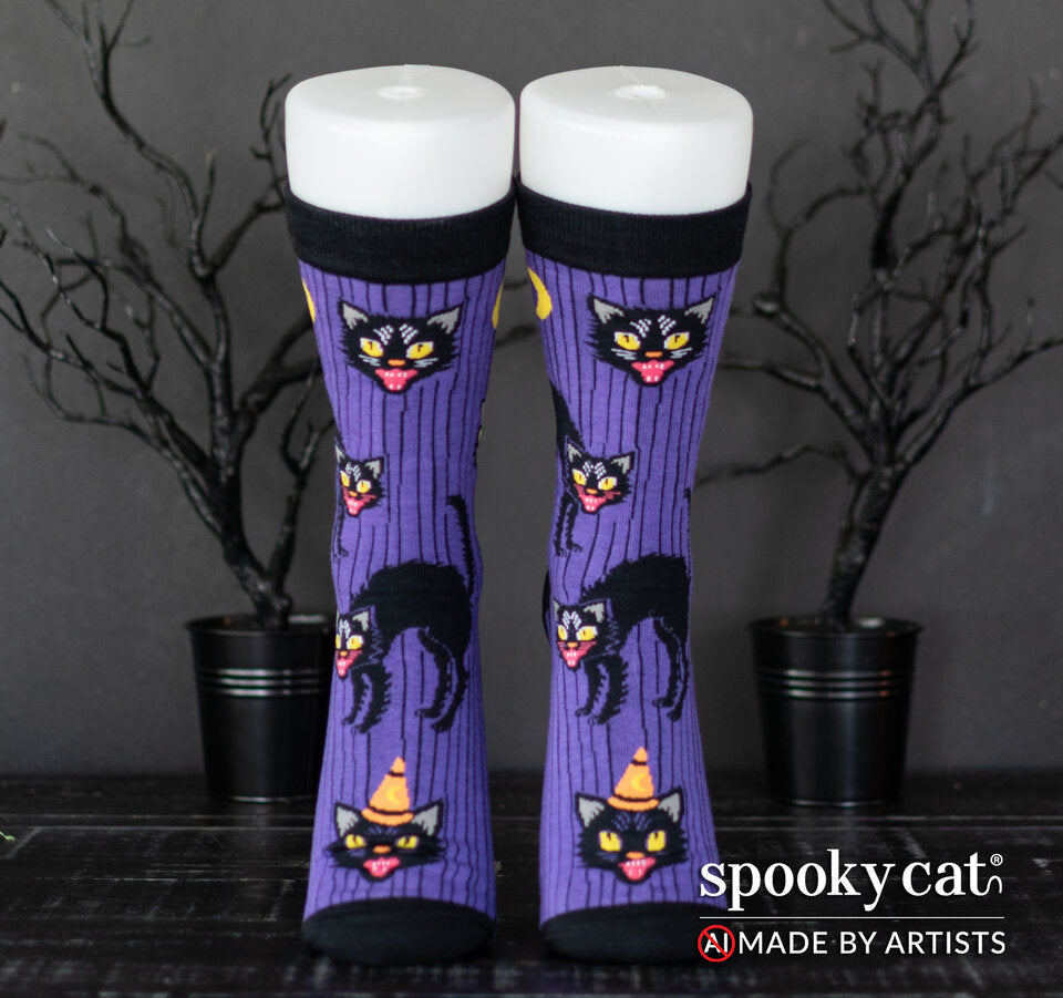 Vintage inspired purple Halloween socks with black cats, moons, and black stripes worn on a foot mannequin.