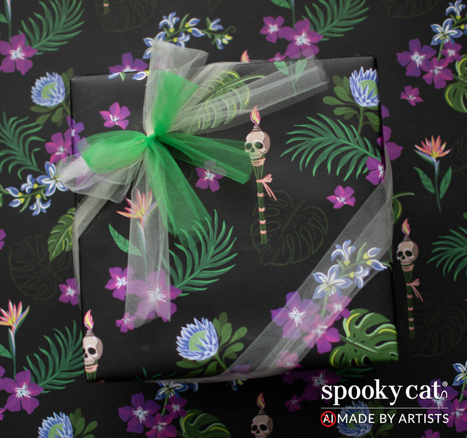 Black gothic tiki floral gift wrap featuring tropical flowers, palm leaves, and skull tiki torch illustrations wrapped around a gift box with green and white tulle ribbon.