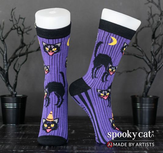 Vintage inspired purple Halloween socks with black cats, moons, and black stripes worn on a foot mannequin.